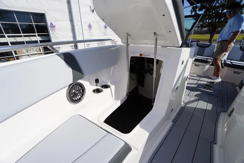 Slide: The Image of 2026 Chaparral 250 OSX boat interior with open storage compartment and seating area. - 14