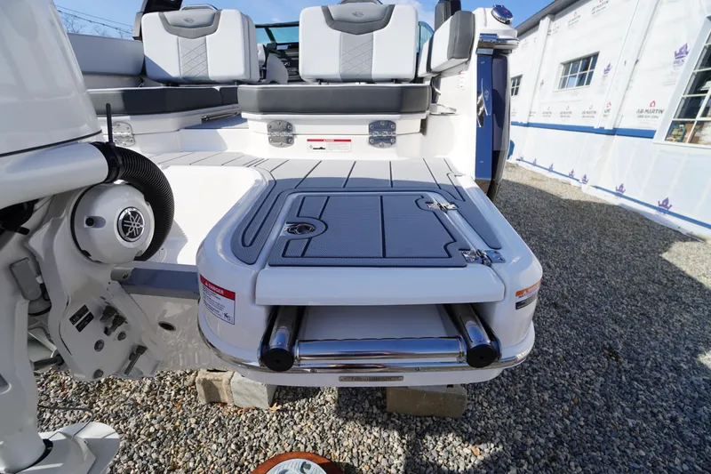Slide: The Image of 2026 Chaparral 250 OSX boat swim platform with ladder and seating area. - 54