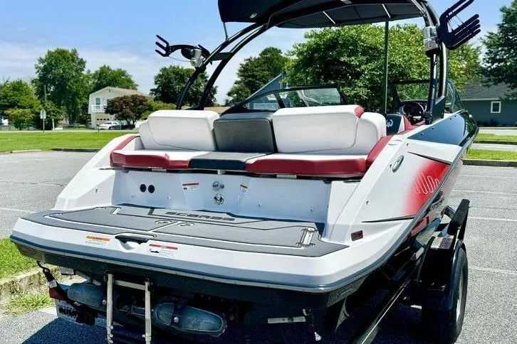 Slide: The Image of 2015 Scarab 215 HO Impulse boat, rear view, parked on trailer in sunny setting. - 6