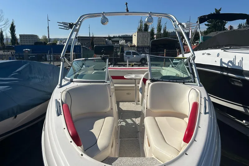 Slide: The Image of 2004 Rinker 212 Captiva Bowrider with white and red seating, docked outdoors. - 11