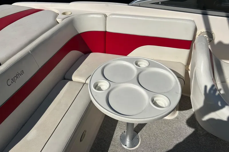 Slide: The Image of 2004 Rinker 212 Captiva Bowrider interior with red and white seating, round table. - 13