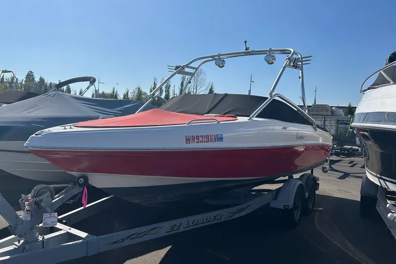 Slide: The Image of 2004 Rinker 212 Captiva Bowrider on trailer, red and white, parked outdoors. - 2