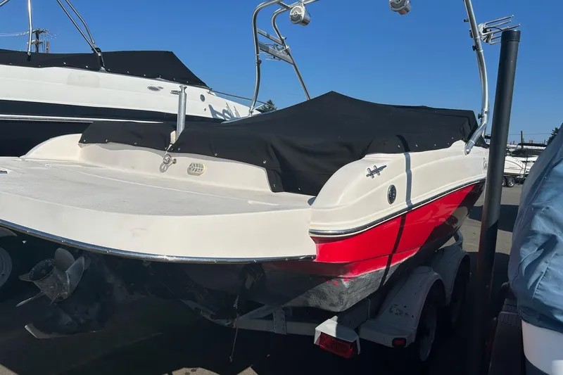 Slide: The Image of 2004 Rinker 212 Captiva Bowrider with black cover on trailer, rear view. - 20