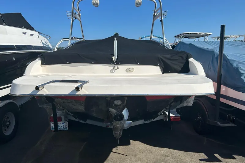 Slide: The Image of 2004 Rinker 212 Captiva Bowrider boat, rear view, covered, in storage. - 21