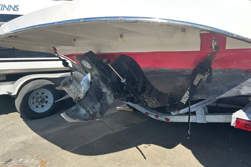 Slide: The Image of 2004 Rinker 212 Captiva Bowrider boat on trailer, showing propeller and hull details. - 23