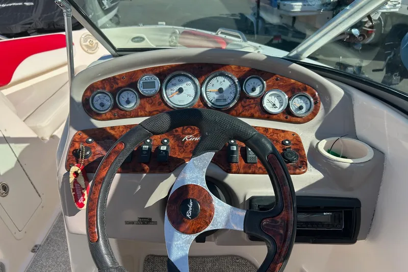Slide: The Image of 2004 Rinker 212 Captiva Bowrider dashboard with wood accents and steering wheel. - 4