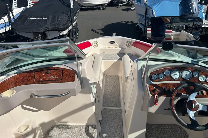 Slide: The Image of 2004 Rinker 212 Captiva Bowrider interior with dashboard and seating area. - 9