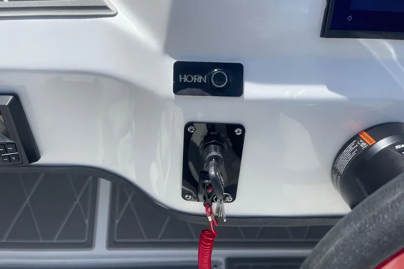 Slide: The Image of Control panel of 2026 Lightning Boat Works Strike 200 with horn button and ignition switch. - 17