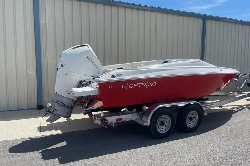 Slide: The Image of 2026 Lightning Boat Works Strike 200 on trailer, red hull, Mercury outboard engine. - 3