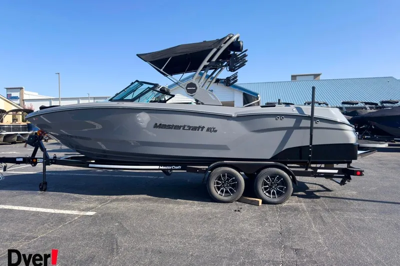 The Image of 2026 MasterCraft NXT23 boat on trailer, parked outdoors, side view. - 0