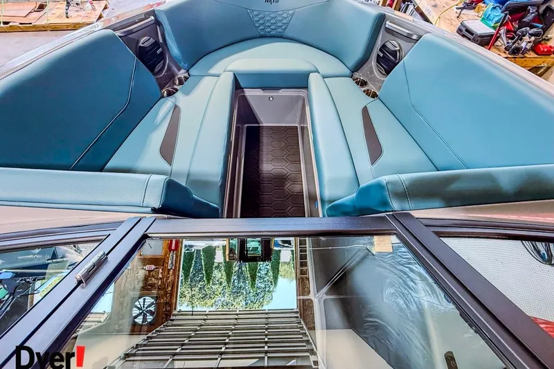 Slide: The Image of 2026 MasterCraft NXT23 boat interior with blue seating and storage compartment. - 10