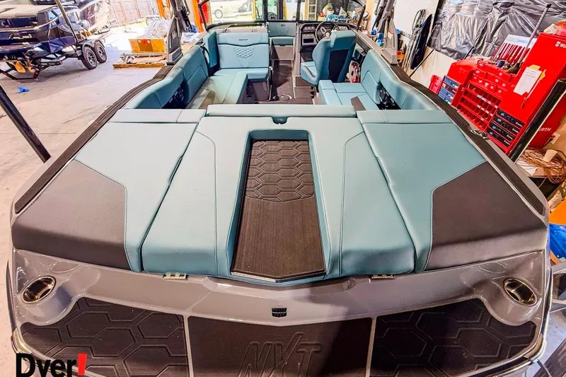 Slide: The Image of 2026 MasterCraft NXT23 boat interior with teal and black seating in a workshop setting. - 6