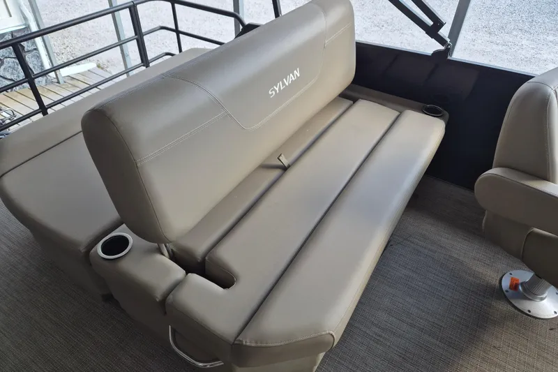 Slide: The Image of 2026 Sylvan Mirage 820 CLZ DH boat interior with beige seating and cup holders. - 11