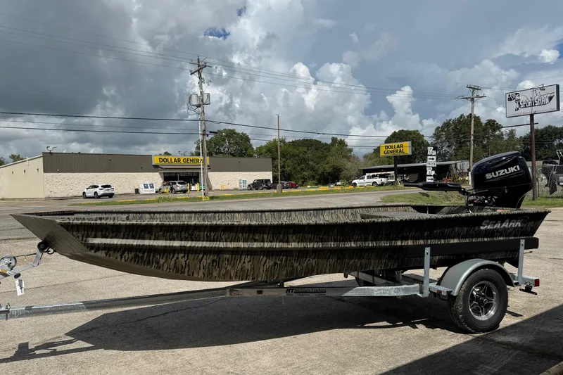 The Image of 2026 SeaArk 1652 Special boat on trailer, parked near Dollar General under cloudy sky. - 1
