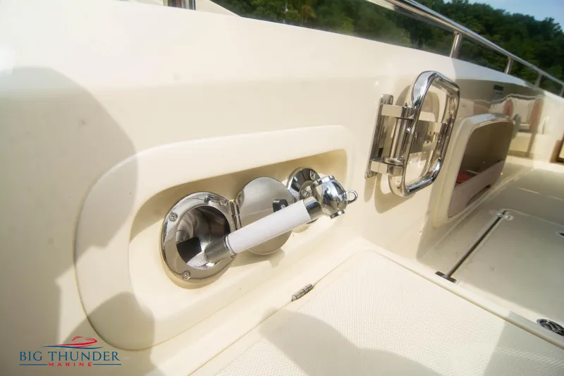 Slide: The Image of 2024 Invictus TT280S boat deck with chrome fixtures and storage compartment. - 13