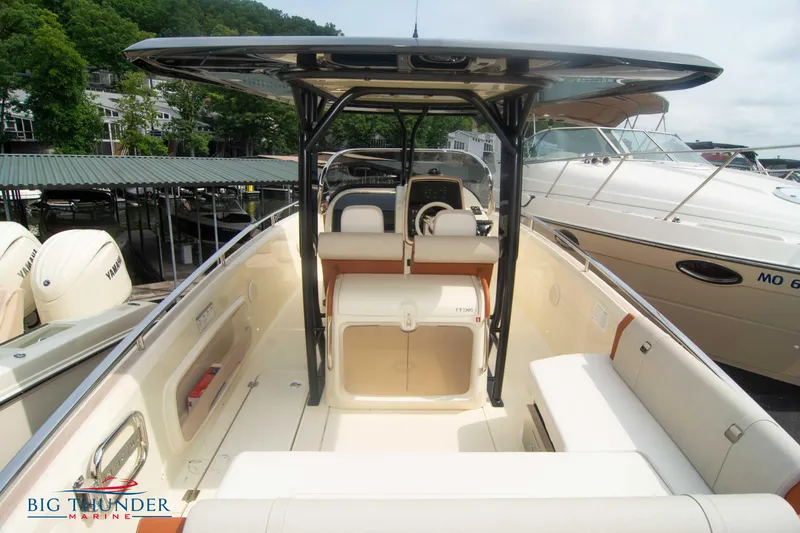 Slide: The Image of 2024 Invictus TT280S boat interior with seating and helm, docked at marina. - 14