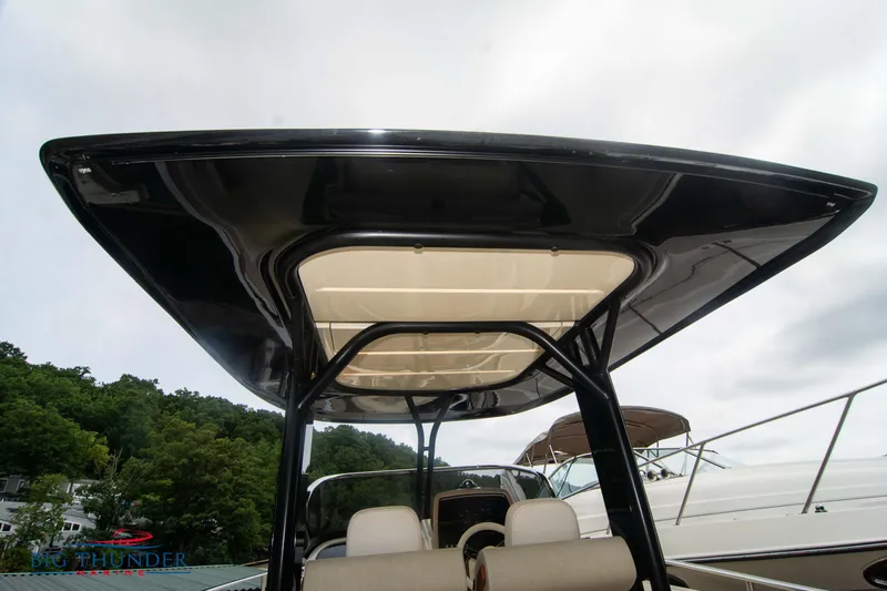 Slide: The Image of 2024 Invictus TT280S boat with sleek black canopy, docked near lush greenery. - 20