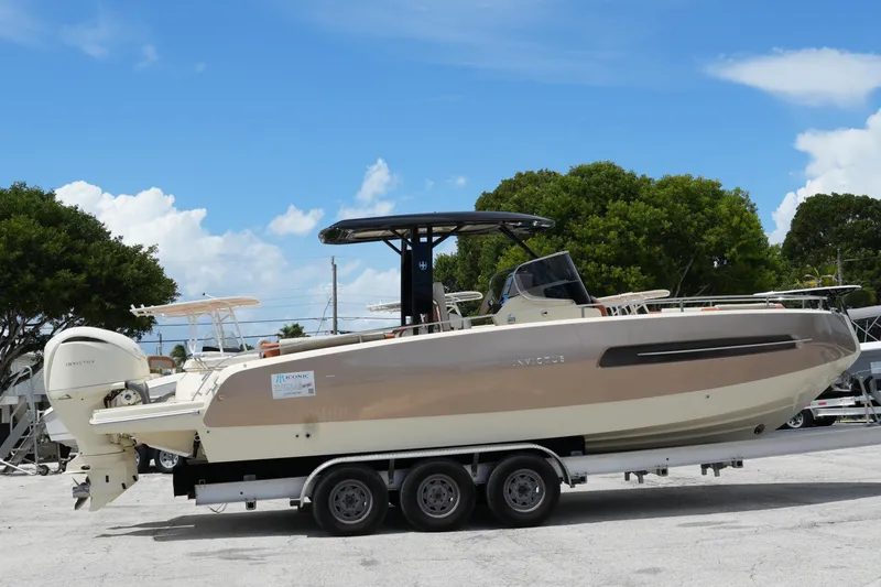 Slide: The Image of 2024 Invictus TT280S boat on trailer, parked outdoors under blue sky. - 3