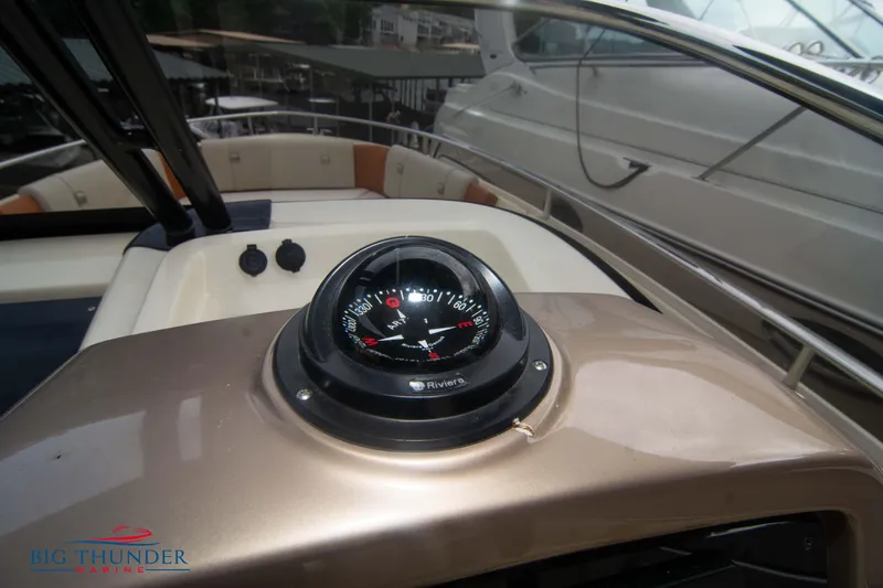 Slide: The Image of 2024 Invictus TT280S boat dashboard with compass, featuring sleek design and modern controls. - 34