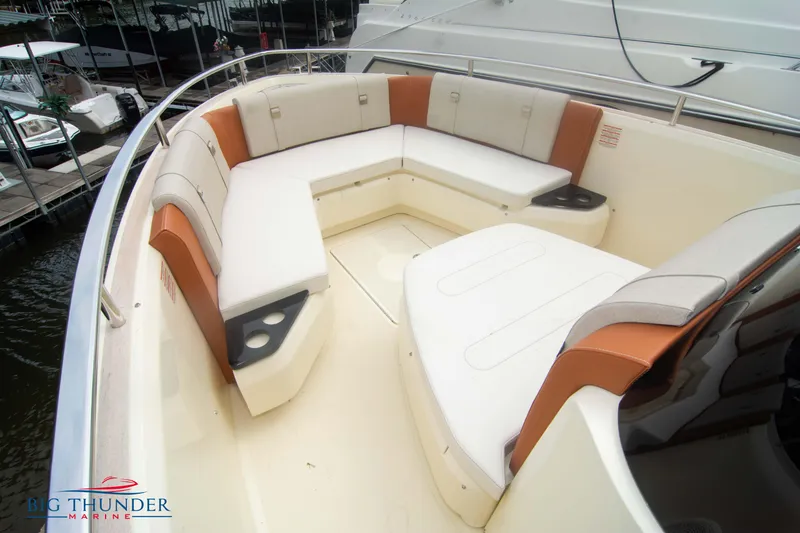 Slide: The Image of 2024 Invictus TT280S boat with spacious seating area and cup holders at a marina. - 37