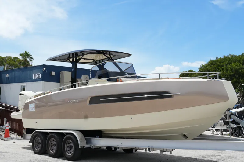 Slide: The Image of 2024 Invictus TT280S boat on trailer, sleek design, parked outdoors under blue sky. - 4