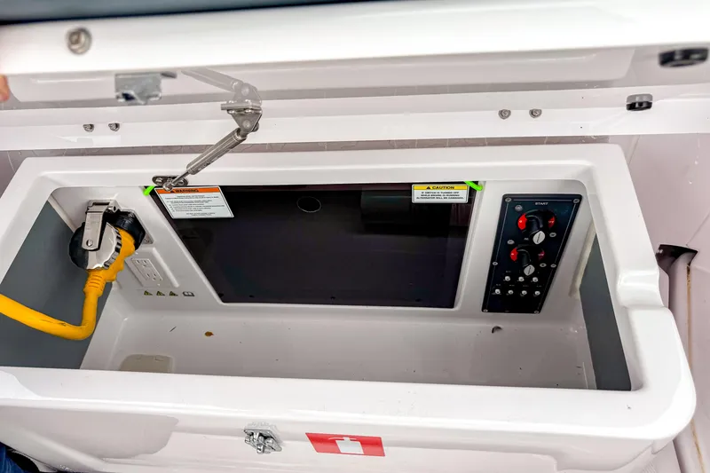 Slide: The Image of 2024 Axopar 25 Cross Top boat control panel with yellow power cable and warning labels. - 11