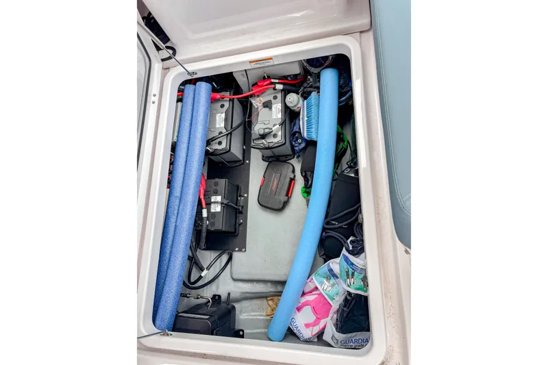 Slide: The Image of 2024 Axopar 25 Cross Top storage compartment with batteries and equipment. - 12