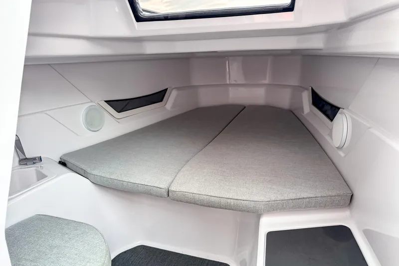 Slide: The Image of 2024 Axopar 25 Cross Top cabin interior with cushioned seating and modern design. - 7