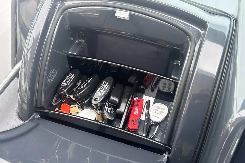 Slide: The Image of Storage compartment in 2022 Formula 350 Crossover Bowrider I/O with keys and tools. - 17