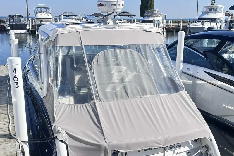Slide: The Image of 2022 Formula 350 Crossover Bowrider I/O docked at marina, covered with protective canopy. - 3