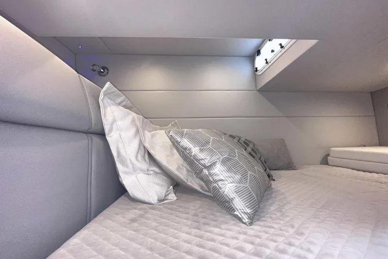 Slide: The Image of 2022 Formula 350 Crossover Bowrider I/O cabin interior with plush bedding and modern design. - 33