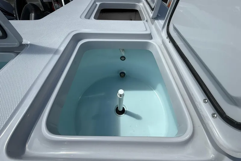 Slide: The Image of 2026 Action Craft 20 Flatsmaster boat livewell, open lid, white interior. - 16