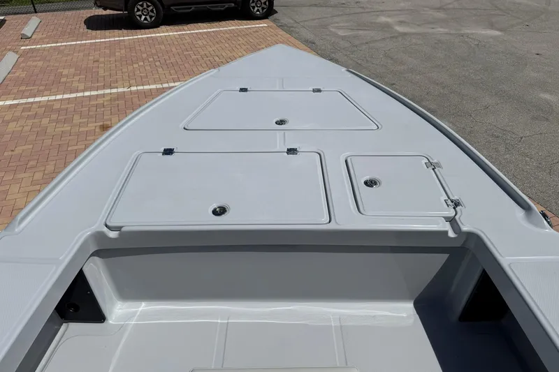 Slide: The Image of 2026 Action Craft 20 Flatsmaster boat deck with storage compartments in a parking lot. - 24