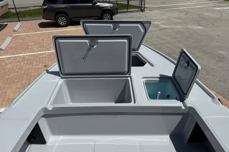 Slide: The Image of 2026 Action Craft 20 Flatsmaster boat storage compartments open in parking lot. - 25
