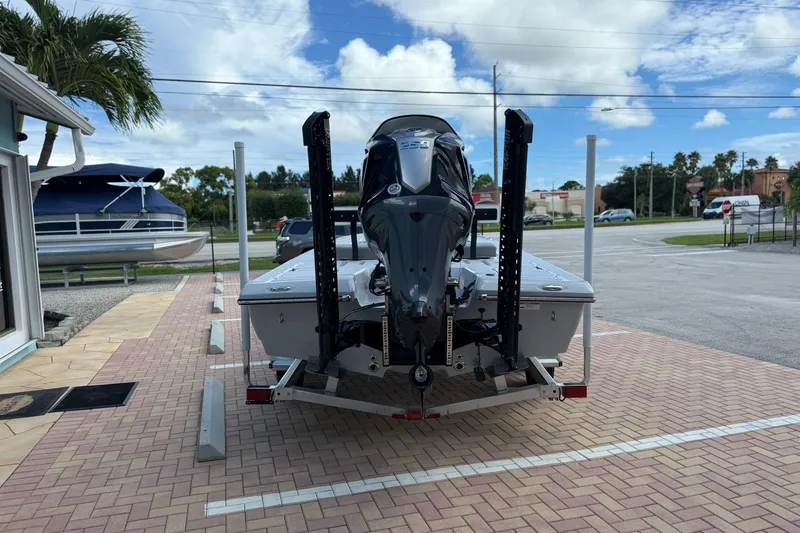 Slide: The Image of 2026 Action Craft 20 Flatsmaster boat on trailer, parked outdoors under a partly cloudy sky. - 3