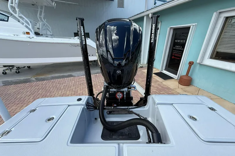 Slide: The Image of 2026 Action Craft 20 Flatsmaster boat with Minn Kota motor, docked near service area. - 6