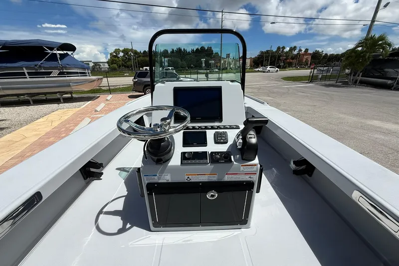 Slide: The Image of 2026 Action Craft 20 Flatsmaster boat console with steering wheel and navigation controls. - 20