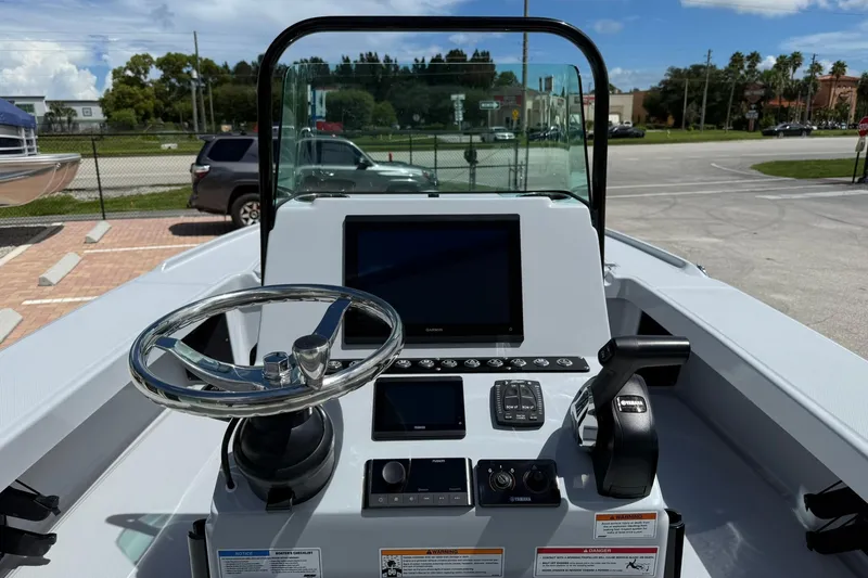 Slide: The Image of 2026 Action Craft 20 Flatsmaster boat dashboard with steering wheel and control panel. - 21