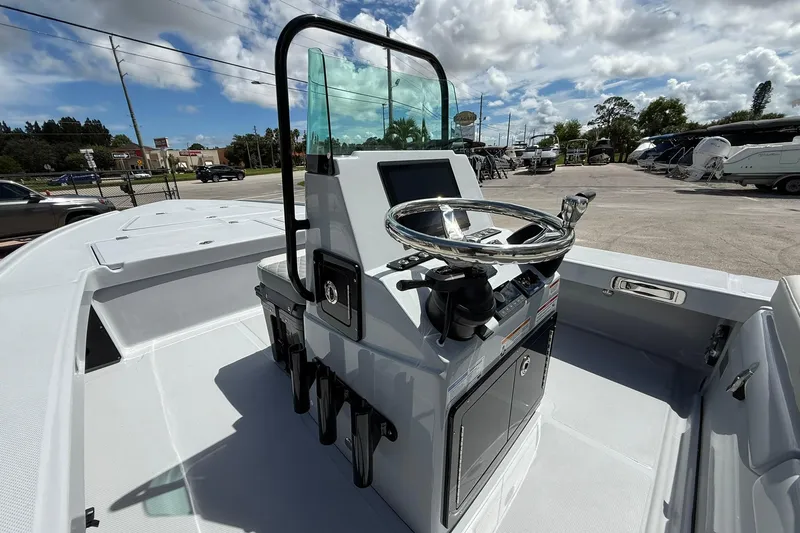 Slide: The Image of 2026 Action Craft 20 Flatsmaster boat with sleek console and steering wheel, under a partly cloudy sky. - 22