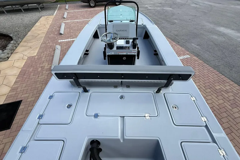 Slide: The Image of 2026 Action Craft 20 Flatsmaster boat with Garmin console, parked on brick pavement. - 7