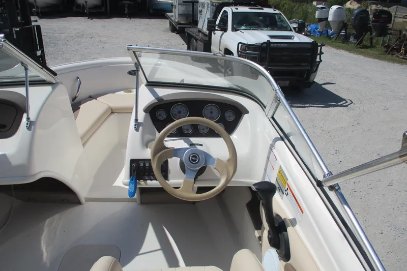 Slide: The Image of 2007 CHAPARALL 180 boat interior with steering wheel and dashboard, parked near a white truck. - 7