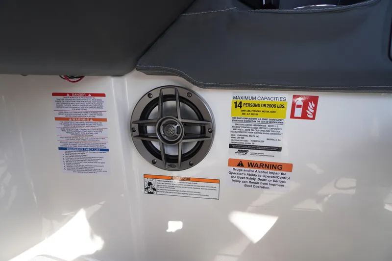 Slide: The Image of 2026 Chaparral 250 OSX boat capacity and safety warning labels near speaker. - 35