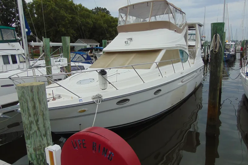 Slide: The Image of 1999 Maxum 4100 SCA yacht docked at marina, surrounded by other boats. - 1
