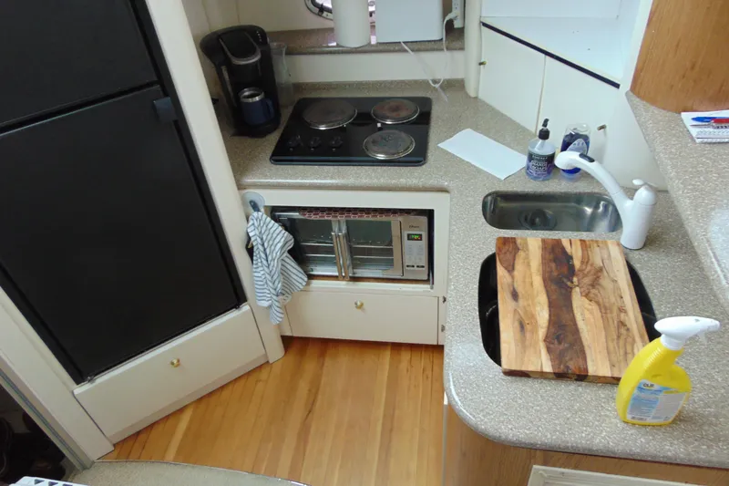 Slide: The Image of Compact kitchen in a 1999 Maxum 4100 SCA yacht with appliances and wooden cutting board. - 17