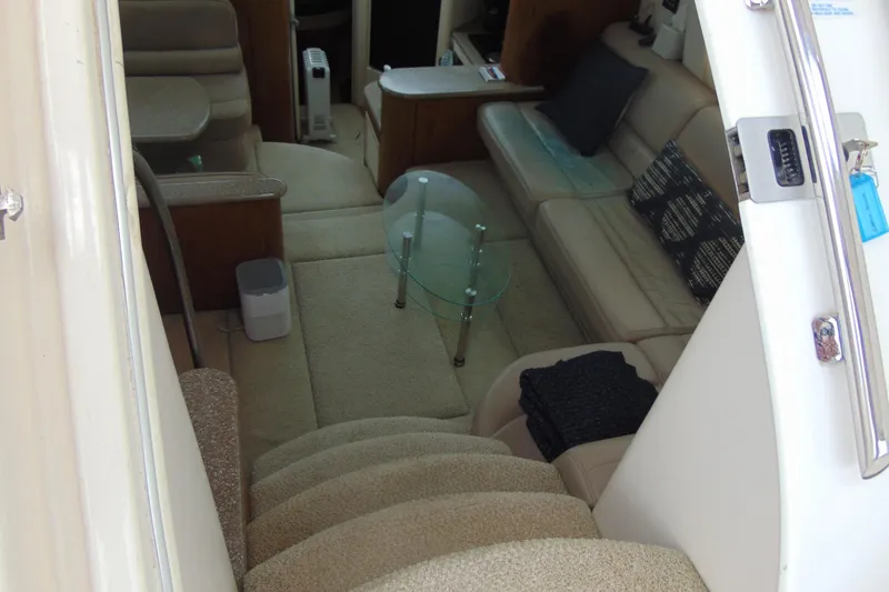 Slide: The Image of Interior of 1999 Maxum 4100 SCA yacht with beige seating and glass table. - 19