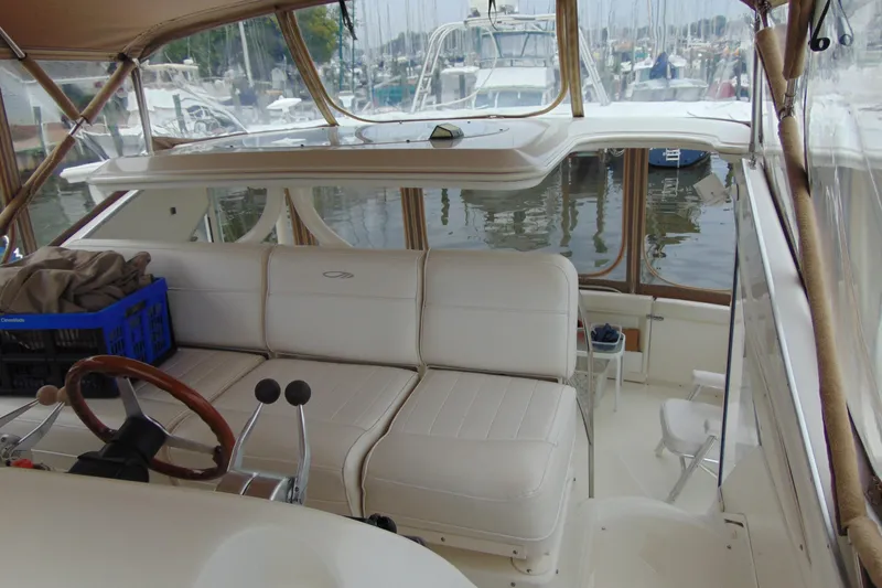 Slide: The Image of 1999 Maxum 4100 SCA yacht interior with white seating and wooden steering wheel. - 20