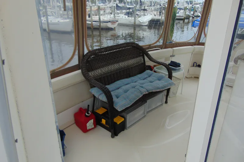 Slide: The Image of 1999 Maxum 4100 SCA yacht interior with wicker seating and marina view. - 24