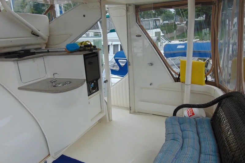 Slide: The Image of 1999 Maxum 4100 SCA yacht interior with kitchenette, seating, and marina view. - 4