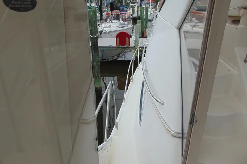 Slide: The Image of 1999 Maxum 4100 SCA yacht docked, showing side deck and railing. - 5