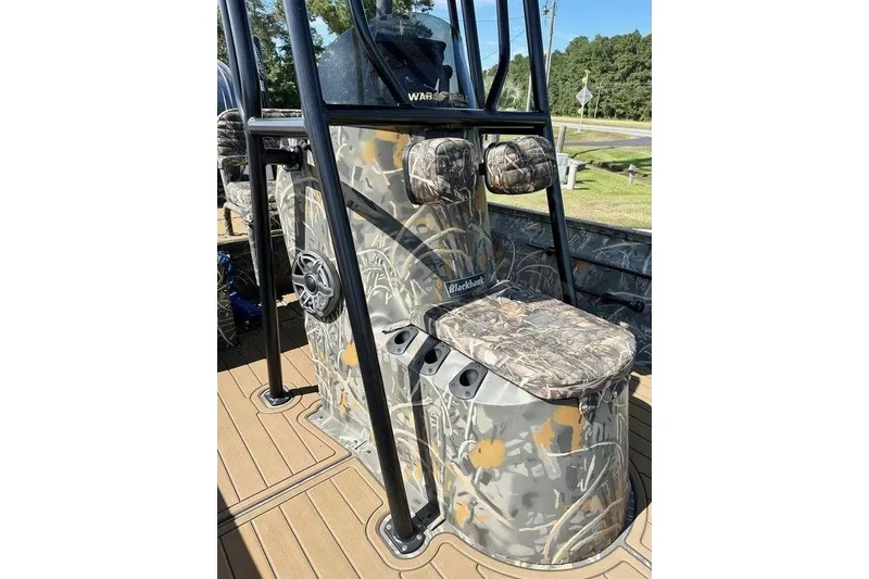 Slide: The Image of 2024 War Eagle 2170 Blackhawk boat with camouflage design and seating, outdoors. - 2